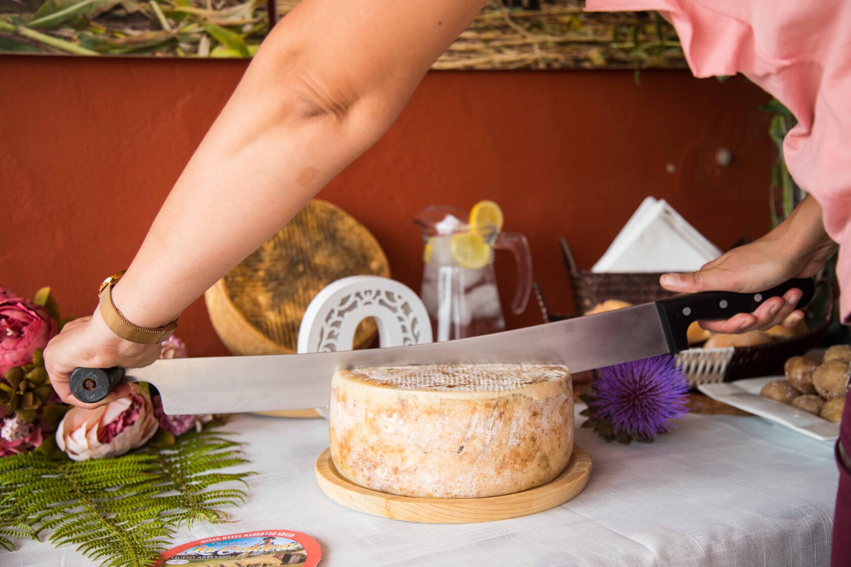 Queseria la Caldera detalle de corte de queso con cuchillo por manos de mujer